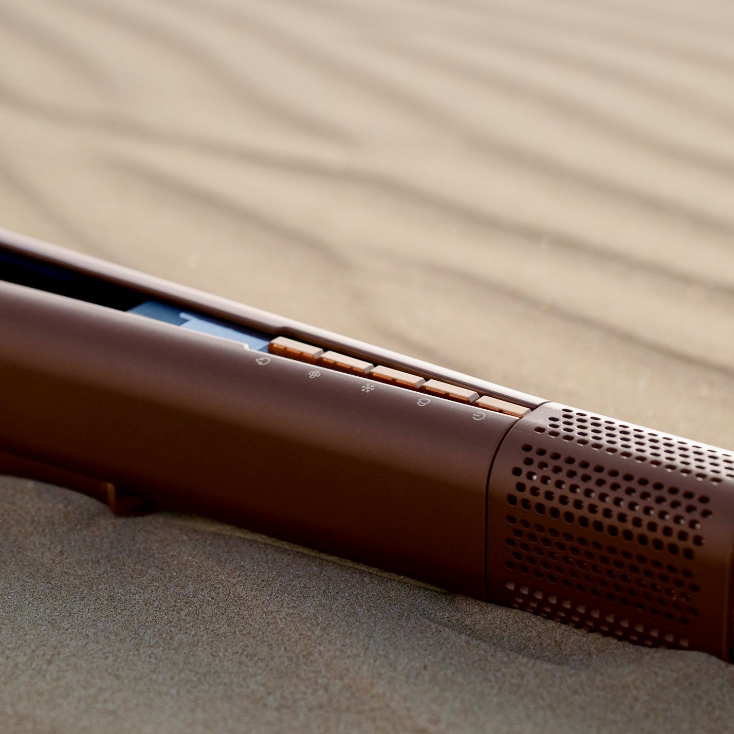 Wet to dry air straightener luxury hair tool in amber finish close up in the desert.